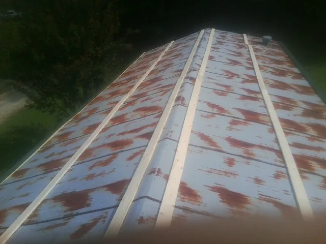 Rusted metal roof panels with new wood purlins before replacement — Storm Damage Roof Repair in Lincoln Park by Roofing Brothers